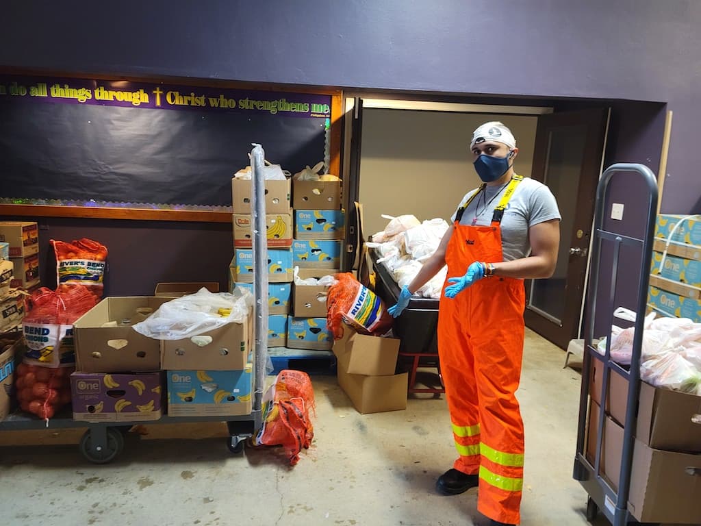 Volunteer standing in room with food boxes