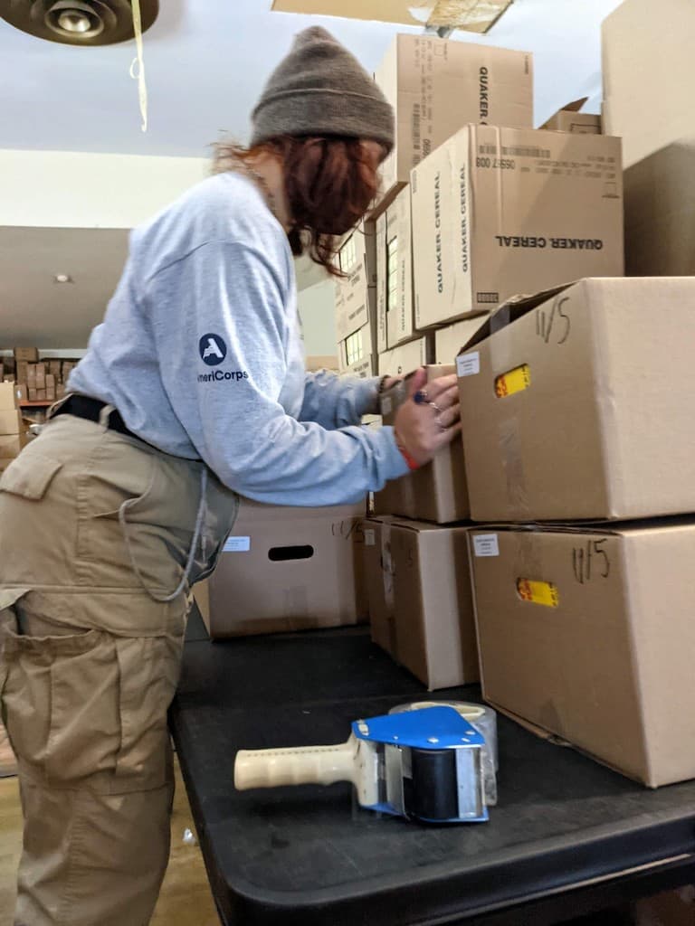 Volunteer touching boxes stacked on table